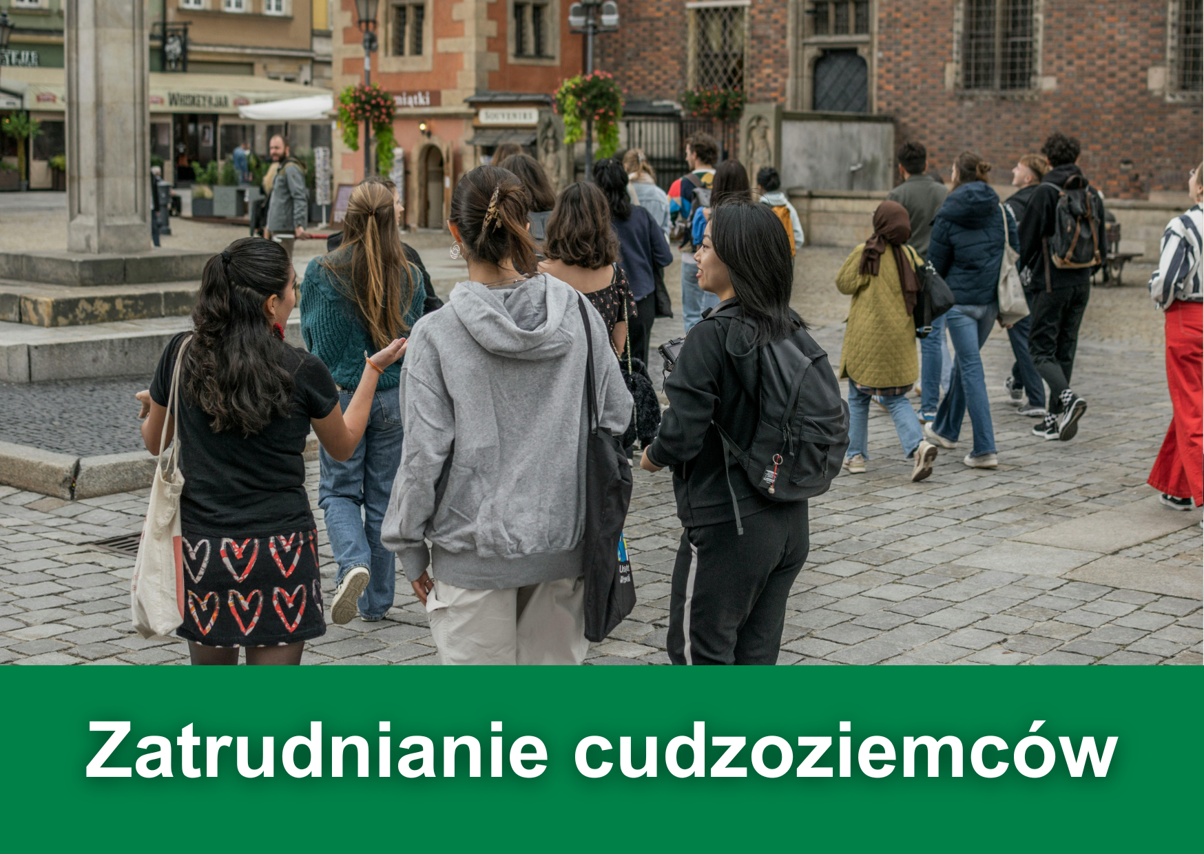 Biały napis "Zatrudnianie Cudzoziemców" na zielonym tle. W tle zdjęcie grupy osób zwiedzających miasto.