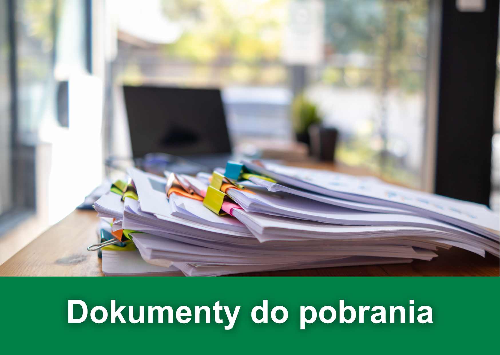 Biały napis "Dokumenty do pobrania" na zielonym tle. W tle zdjęcie dokumentów leżących przy laptopie.